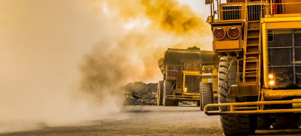 Large dump trucks on a sandy construction site