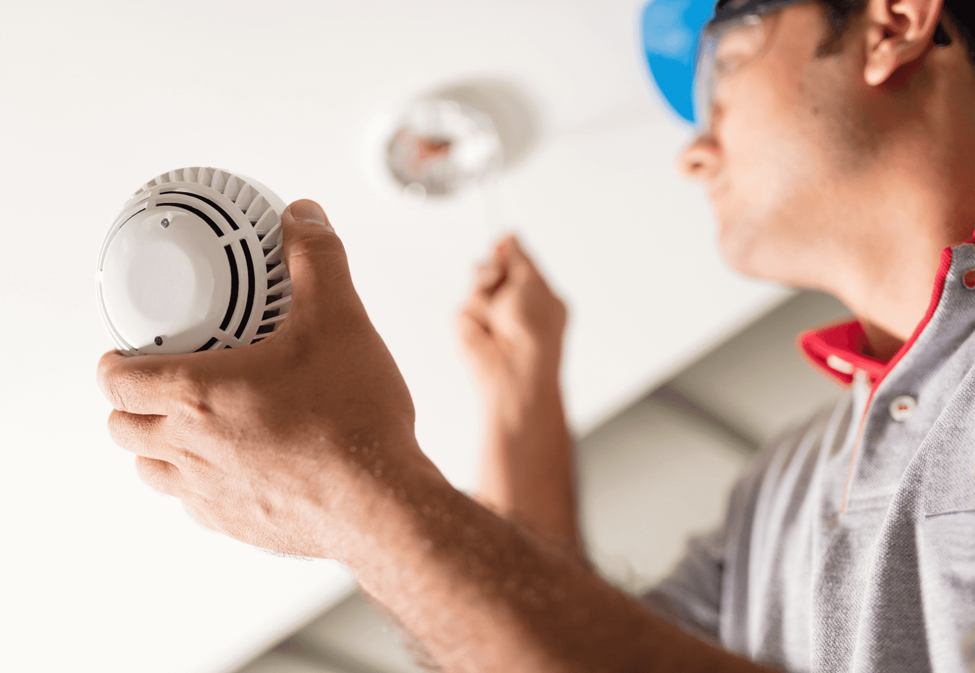 A large Liebherr 9350 excavator with crawler tracks digs through rocky terrain at a mining site under a clear sky, equipped with advanced fire suppression systems for enhanced safety.